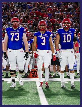 Three football players walking onto the field